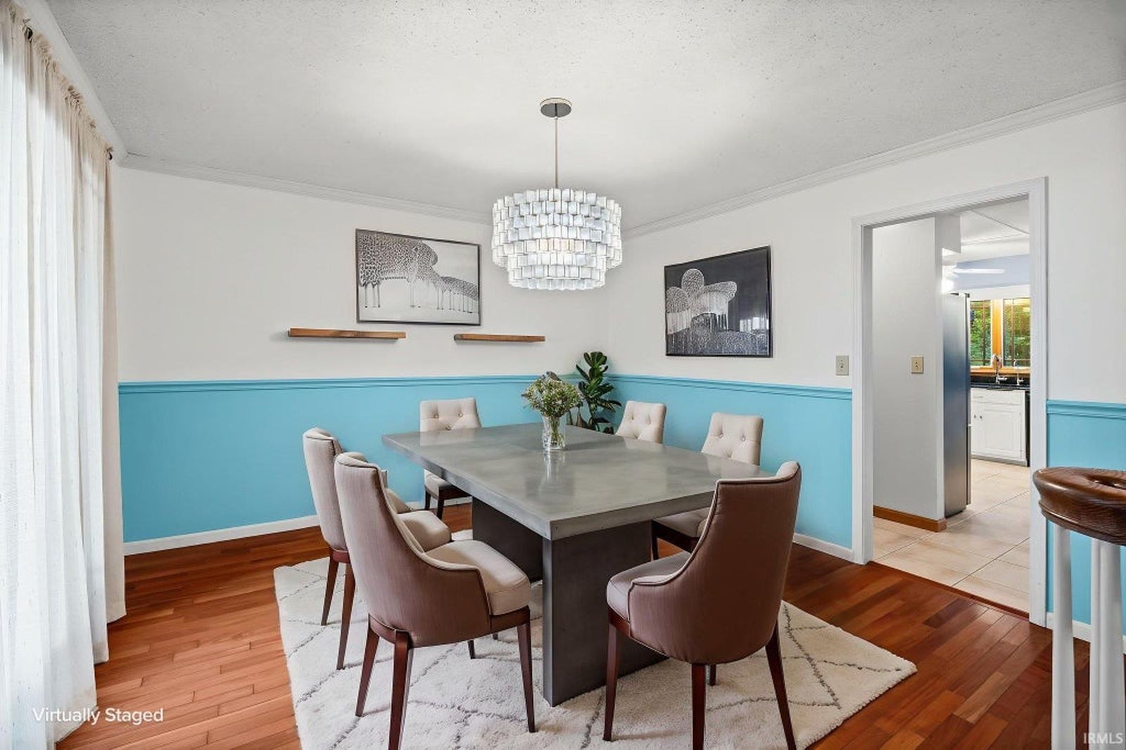 Dining room with hardwood floors, chair rail and chandelier
