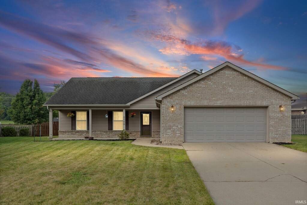 6066 Buchanan Drive, West Lafayette, brick ranch with a two car garage at dusk