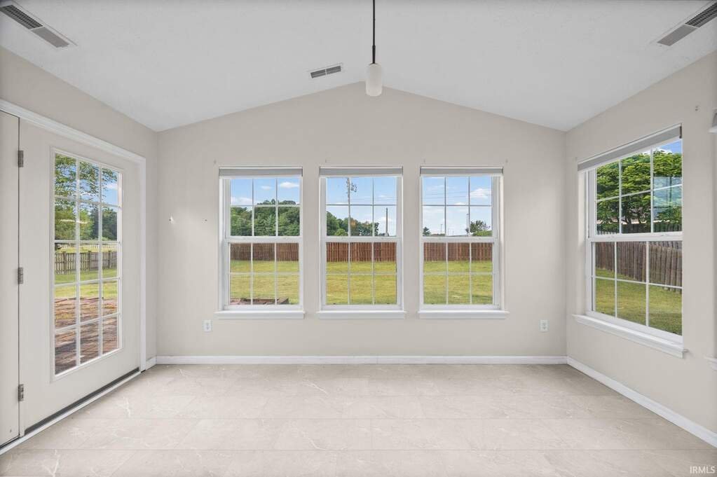 Sunroom with windows on three sides and a door to the backyard